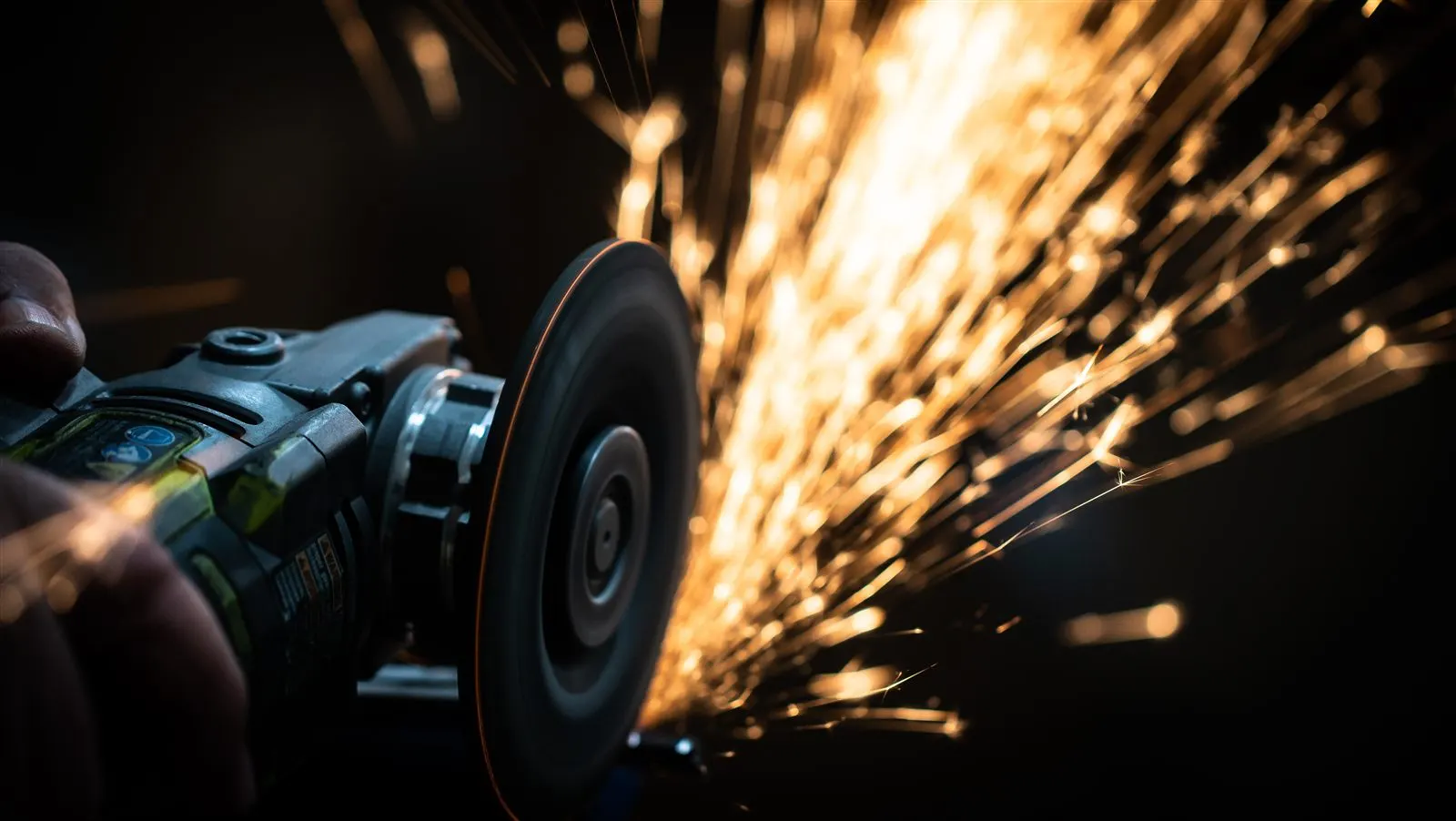 Hand finishing with sparks flying from a grinding wheel