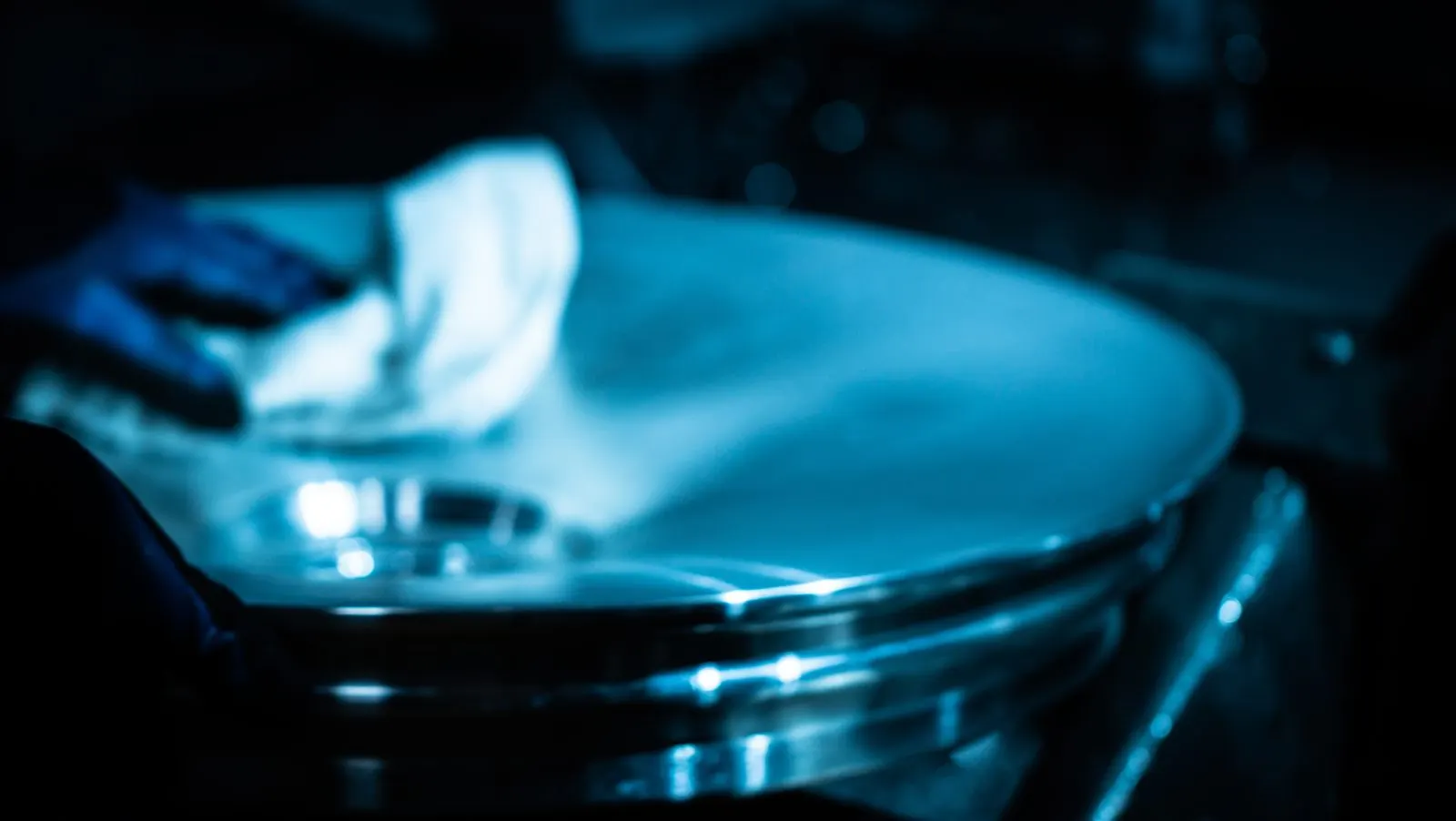 Technician hand-wiping a polished wheel during final inspection
